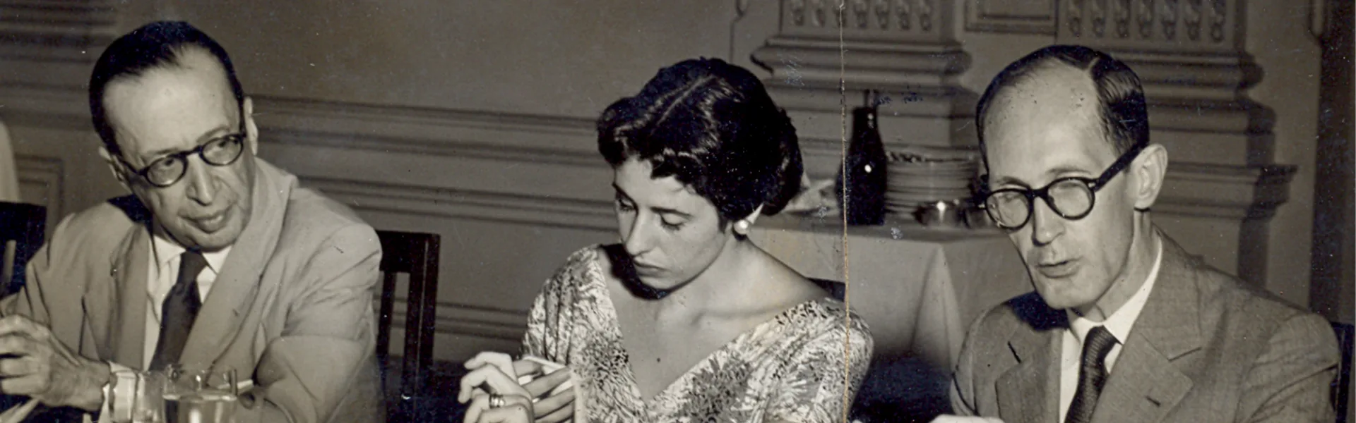 Poetas reunidos à mesa em fotografia antiga